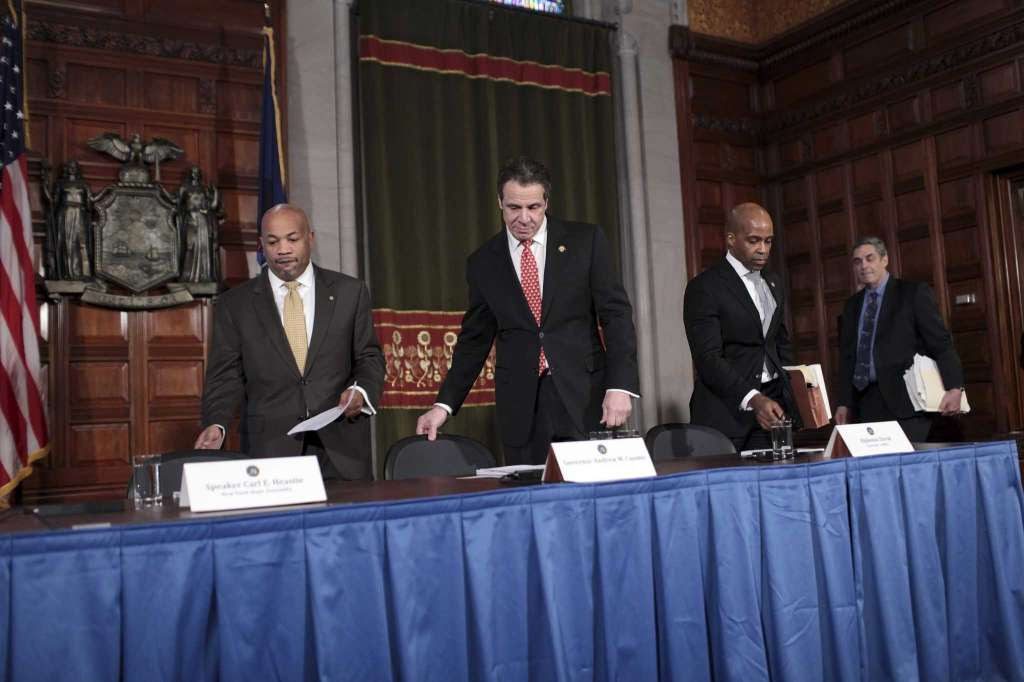 men in suits at hearing table with blue table cloth drape in front