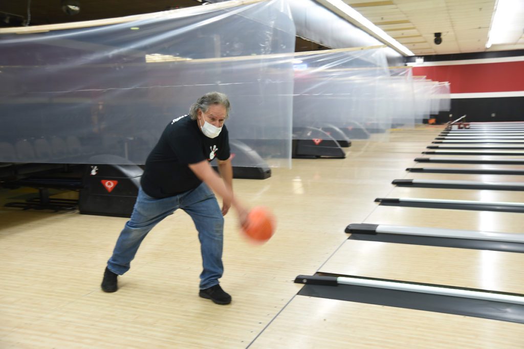 Man bowling with mask on